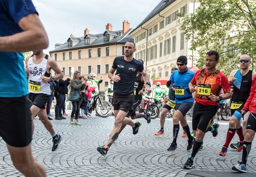 Personnes avec des dossards en train de courir dans les rues de Chambéry